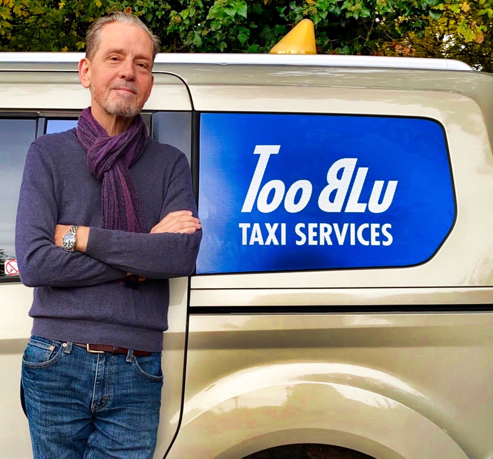 Christian, chauffeur Too Blu, bras croisés devant son fourgon